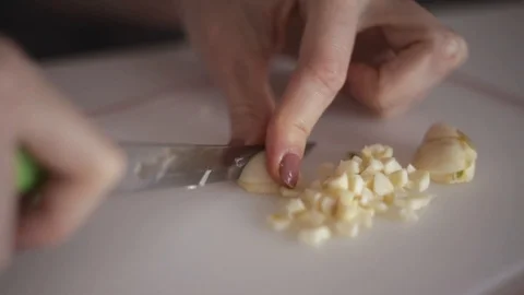 Young woman's hands cut fresh garlic head on white background Stock Footage 122070128
