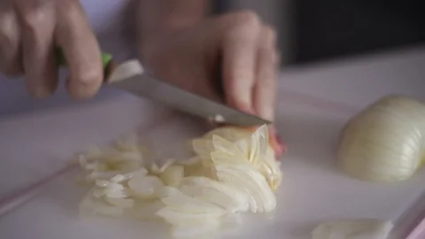 Young woman's hands cut fresh onion head on white background Stock Footage 122071932