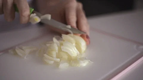 Young woman's hands cut fresh onion head on white background Stock Footage 122072945