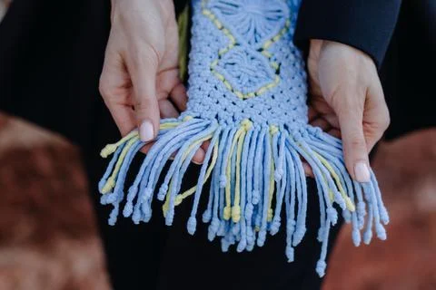 A young woman's hands hold a macrame phone case in Ukrainian colors Stock Photos