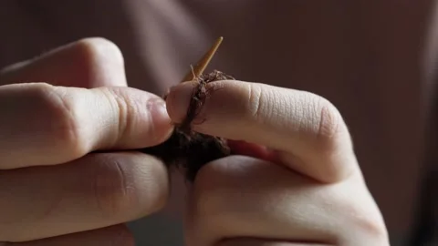 A young woman's hands knit with needles. Video stock 239051120