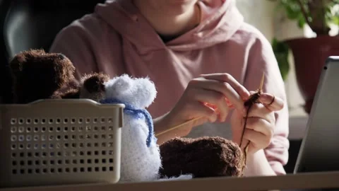 A young woman's hands knit with needles. Video stock 239051124