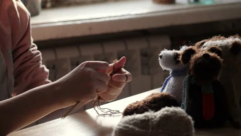 A young woman's hands knit with needles. Video stock 239051131