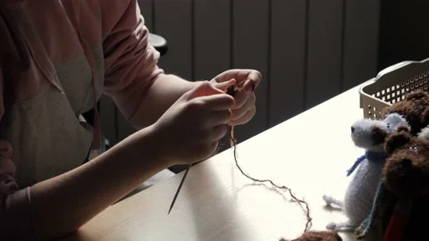 A young woman's hands knit with needles. Video stock 239051139