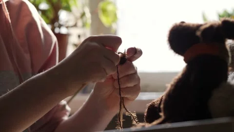A young woman's hands knit with needles. Video stock 239051154