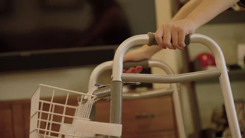 Young womans hands pushing walker through living room Video stock 284040067