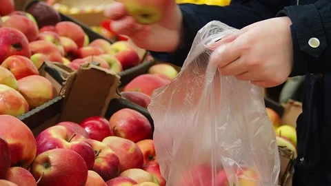 The young woman's hands put apples in a bag. Stock Footage 170549317