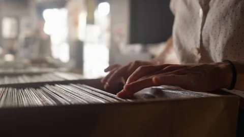 Young woman's hands sifting through vinyl records in a record store Video stock 122575249
