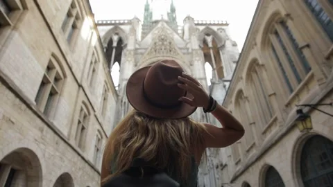 Young wome in a chocolate hat stands in front of the Cathedral and admires the Stockbeeldmateriaal 144411365