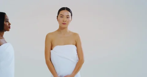 Young women of different ethnicities in white bathing towels looking and smiling Stock Footage 114643200