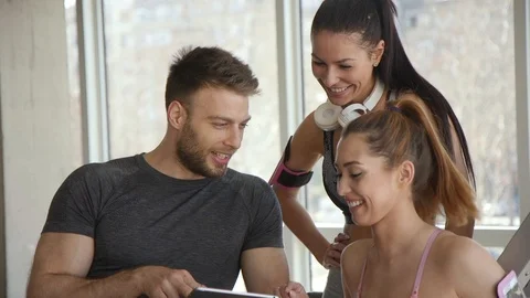 Young women discussing workout progress with fitness instructor Video stock 127177066