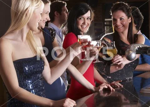 Young women drinking at bar Stock Photos