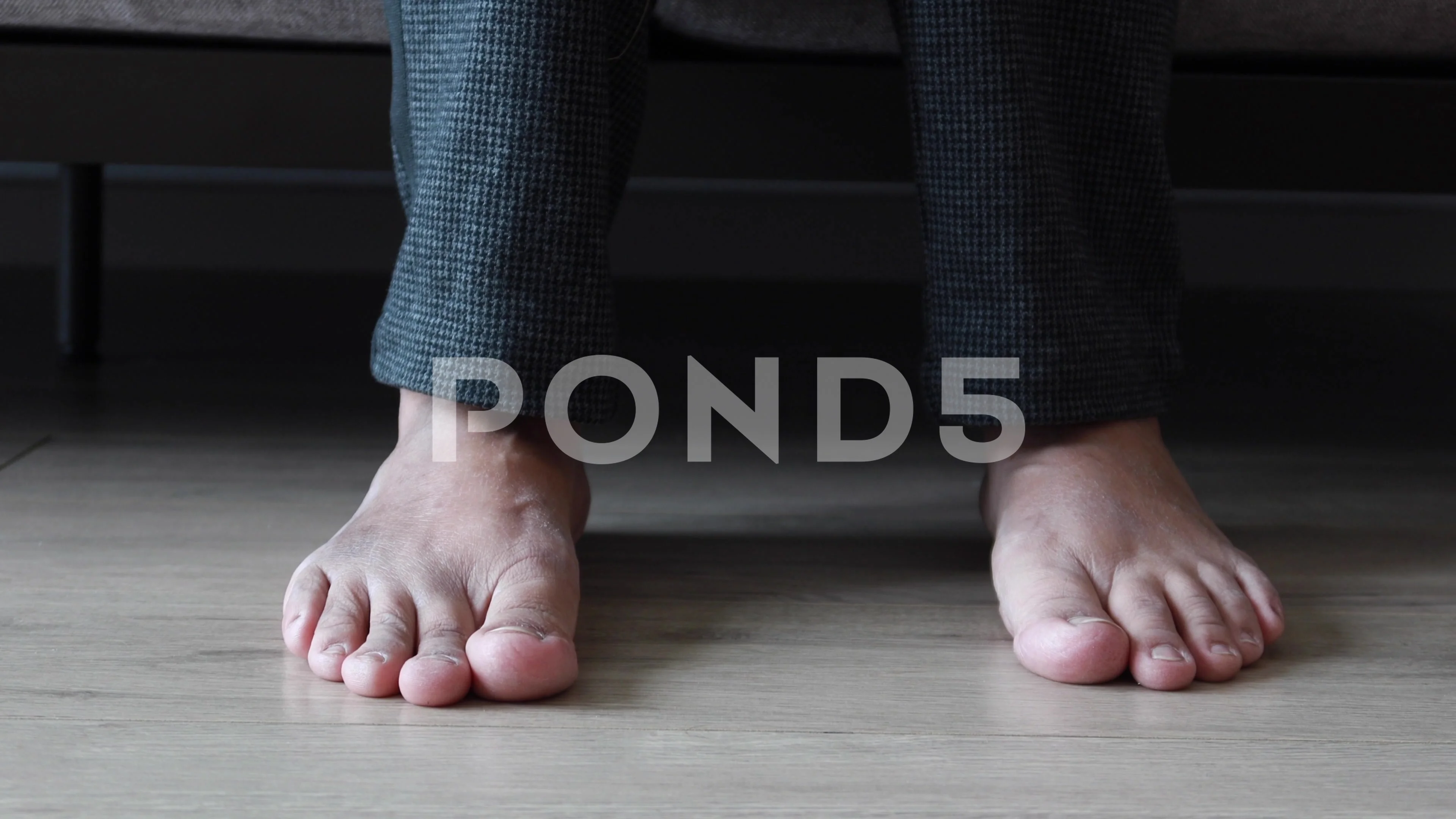 young women feet on wooden floor sitting on sofa