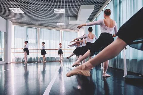 Young women practicing ballet at studio barres in soft daylight Stock Photos