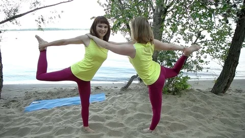 Young women practicing yoga on the sand Video stock 79105953