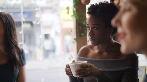 Young women sat in a coffee shop in conversation Stock Footage