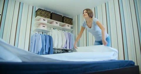 Young women smiling and making bed Stock Footage