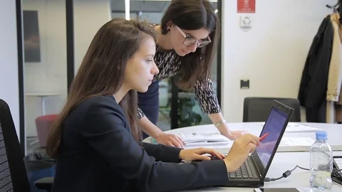 Young women talking while looking at laptop in modern office. Stock Footage 83150271