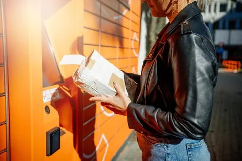 Young women using public parcel machine to sent mail Stock Photos