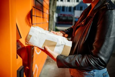 Young women using public parcel machine to sent mail Stock Photos