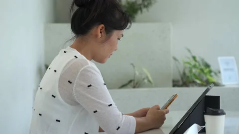 Young women using smartphone to work at cafe. Stockbeeldmateriaal 160038806
