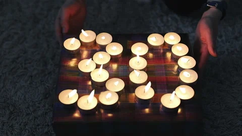 Young women's hands turn the box with a gift and burning candles. Stock Footage 86601686