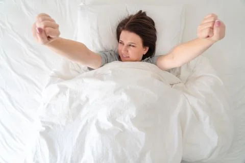 Young wonam stratching in bed after sleeping Stock Photos