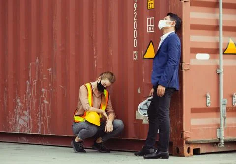 Young worker and engineer sitting failed and stressed at cargo container Fotos Stock