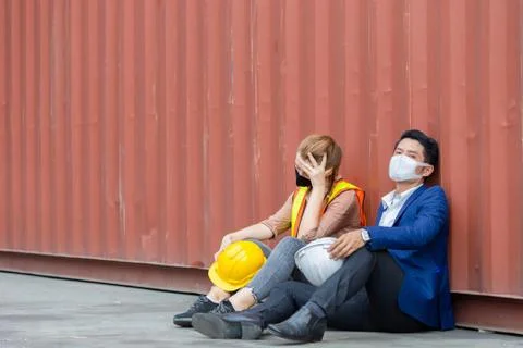 Young worker and engineer sitting failed and stressed at cargo container 写真素材
