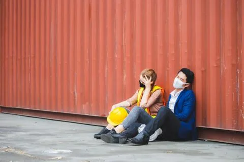 Young worker and engineer sitting failed and stressed at cargo container 写真素材