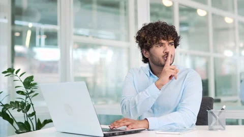 Young worker angry because of noise, holding index finger near lips while work Video stock 237328451
