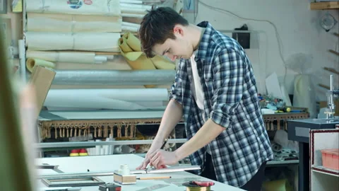 Young worker cutting the glass for frame in frame workshop, suddenly cutting his Vídeo Stock 114301726
