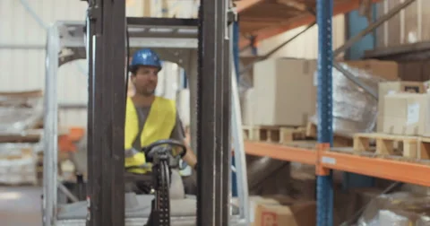 Young worker driving a forklift in a warehouse Stock Footage 65040863