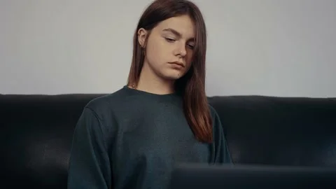 The young worker, focused, typing new ideas for work on her laptop, looks partly Video stock 159481251