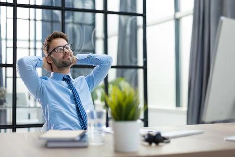 Young worker having break and resting after solving task. Stock Photos