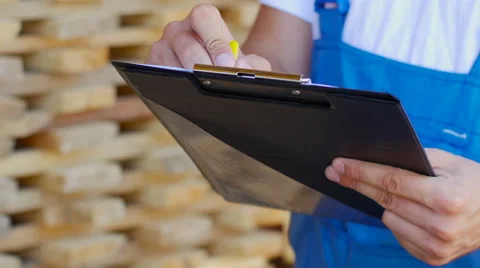 Young worker making an inventory of stock on wood Stock Footage 57096657