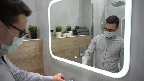 Young worker man clean hands using hand sanitizer gel, morning cleanup routine Stock Footage 131462310