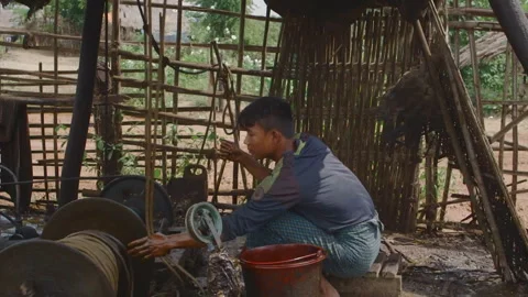 Young worker operating a winch at a Myanmar oil field Video stock 332754928