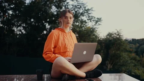 The young worker, optimistic who works concentrated in the park then raises her 库存影片 164464838