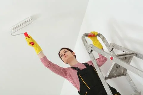 Young worker paint ceiling in a room Stock Photos