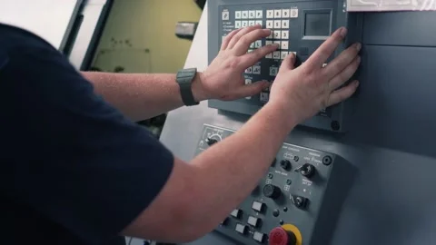 Young worker programming lathe machine in factory Stock Footage 141384616