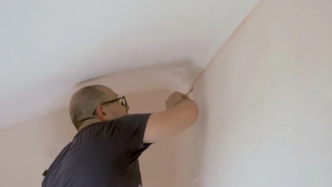 Young worker using  brush for corners to finishing the edge of ceiling 動画素材 130750408