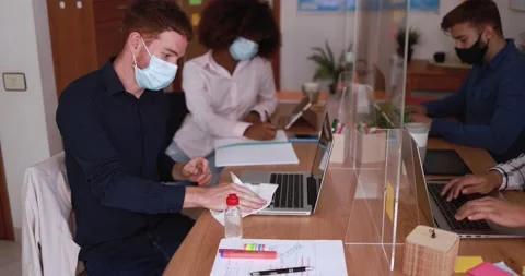Young worker using sanitizer gel to disinfect his laptop computer Stock Footage 141049868