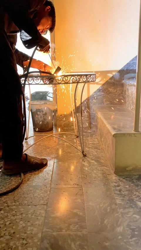 A young worker is welding an old metallic chair in slow motion. Stock Footage 340410971