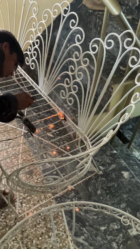 A young worker is welding an old metallic chair in slow motion. Stock Footage 340410981