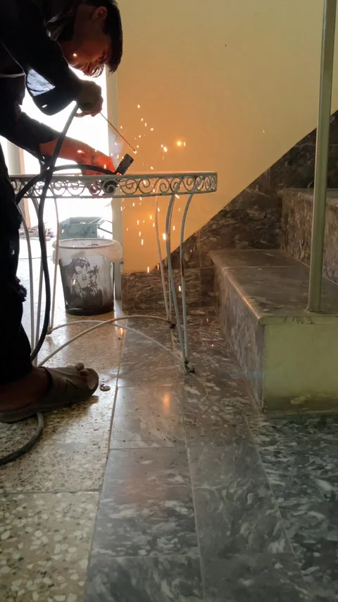 A young worker is welding an old metallic chair in slow motion. Stock Footage 340410985