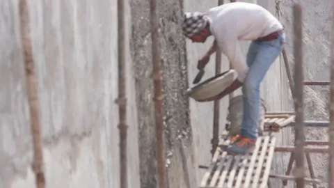 Young worker wetting the newly cemented wall Stock Footage 77447658