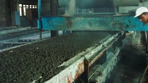A young worker working at a cement factory with a shovel. The interior of a.. Stock Footage 245937755