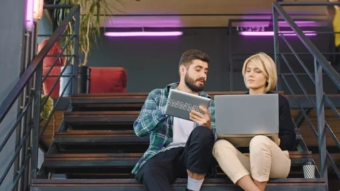 Young workers multiethnic on the office stairs analyzing the plan of work using Stock Footage 122593515