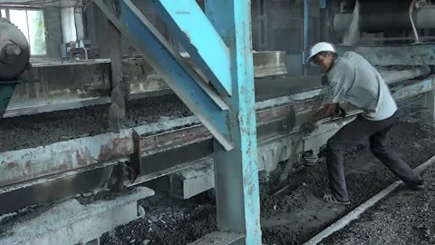 Young workers work with a shovel at a cement factory. Stock Footage 245944132
